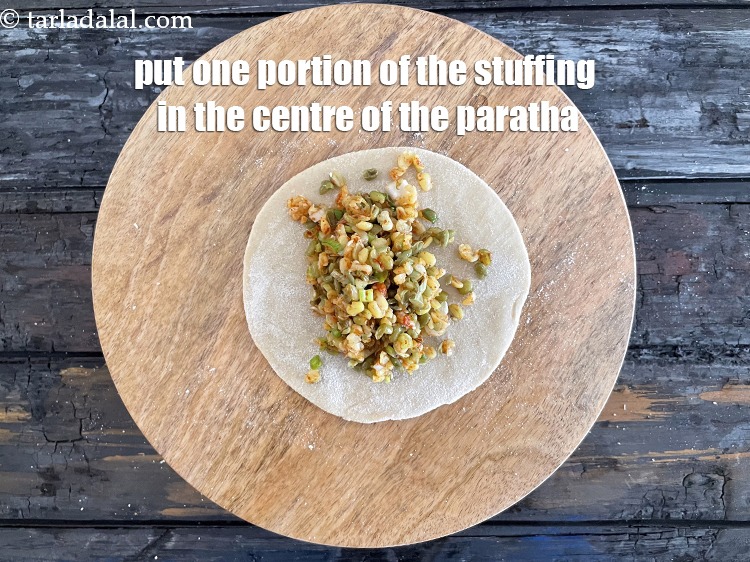 Step 31 – <meta charset="UTF-8" />Place one portion of the stuffing in the centre of the paratha.