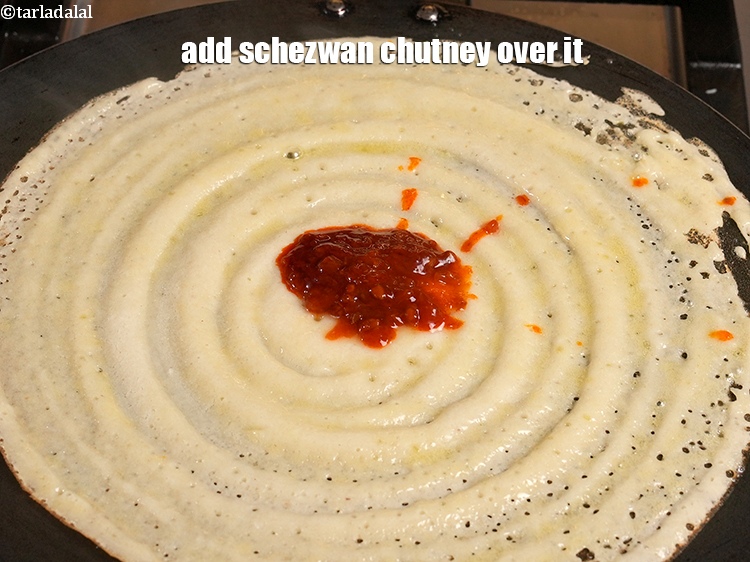Step 31 – Add 1 tbsp <a href="https://www.tarladalal.com/glossary-schezwan-sauce-schezuan-sauce-1872i">schezwan chutney</a> over it.