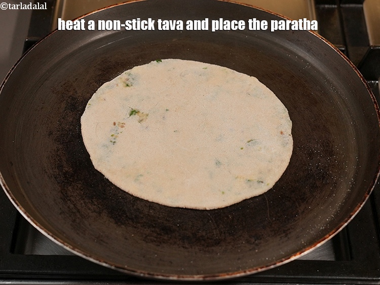 Step 32 – Heat a non-stick tava (griddle) and place the paratha.