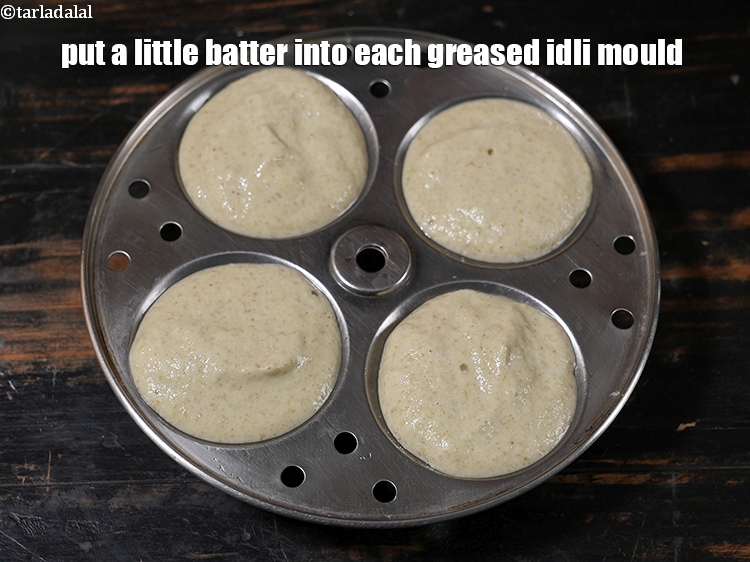 स्टेप 30 – प्रत्येक चुपडे हुए इडली मोल्ड में थोड़ा सा बैटर डालें। …