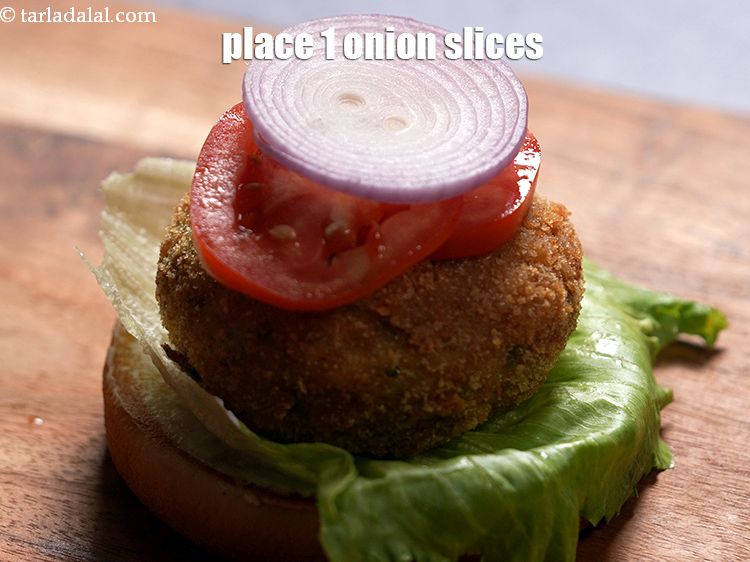 Step 37 – Place 1&nbsp;<a href="https://www.tarladalal.com/glossary-sliced-onions-745i">sliced onions</a>.&nbsp;