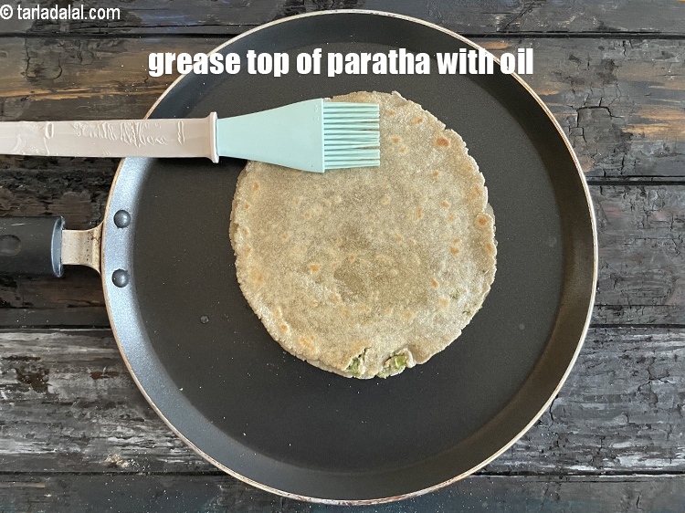 Step 32 – <meta charset="UTF-8" /> Grease the top of the paratha with oil.&nbsp;