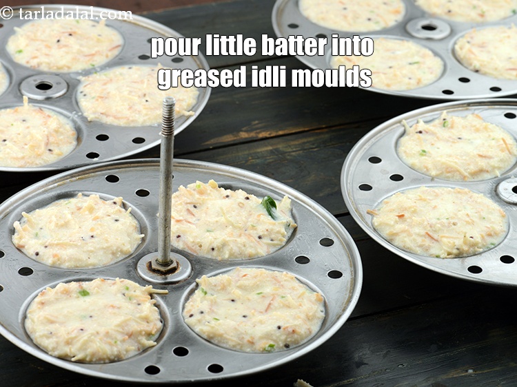 स्टेप 31 – प्रत्येक चिकने इडली सांचे में थोड़ा-थोड़ा बैटर डालें।