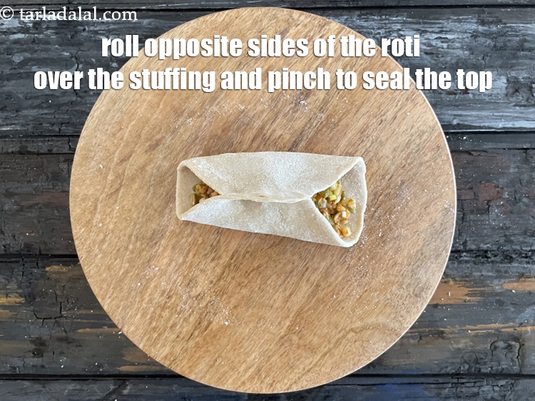 Step 32 – Roll opposite sides of the roti over the stuffing and pinch to seal the top.