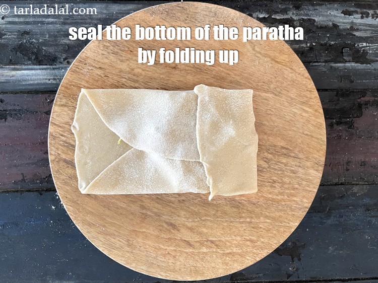 Step 33 – Now fold the bottom edge of the roti to seal the paratha from the bottom.