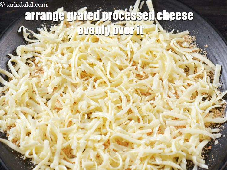 Step 4 – Arrange 1 cup <a href="https://www.tarladalal.com/glossary-grated-processed-cheese-868i">grated processed cheese</a> evenly over it.