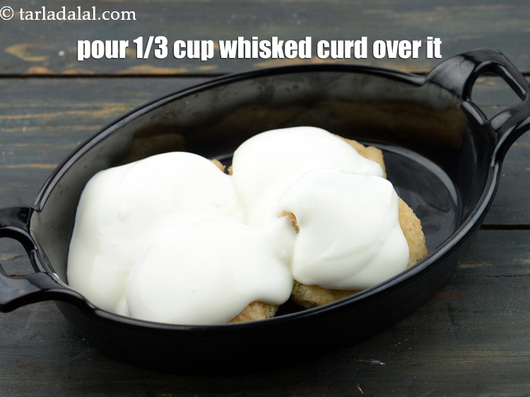 Step 64 – Pour approx. 1/3 cup whisked <a href="https://www.tarladalal.com/glossary-thick-curds-2097i">curds (dahi)</a>&nbsp;evenly over it.