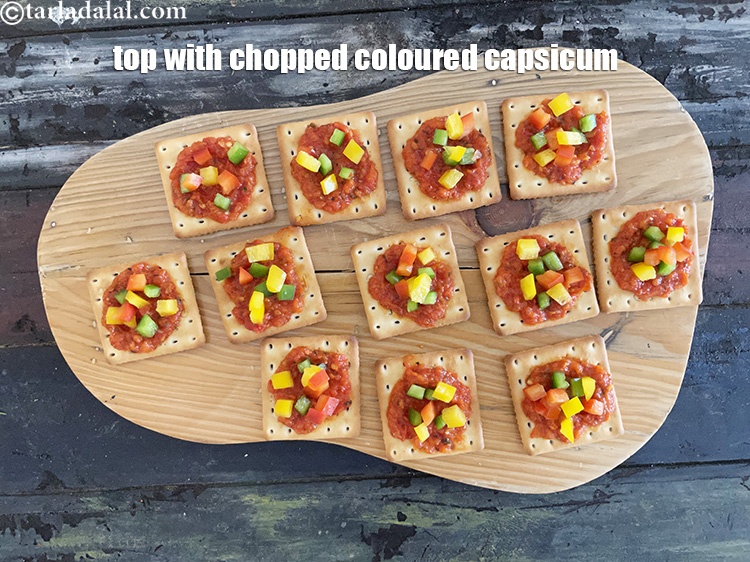 Step 15 – Top each cracker with 1 tsp of chopped colored capsicum. This gives a good crunch …