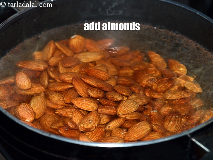 स्टेप 4 – 2 कप <a href=""https://www.tarladalal.com/glossary-almonds-badam-hindi-378i"" target=""_blank"">बादाम</a> डालें।