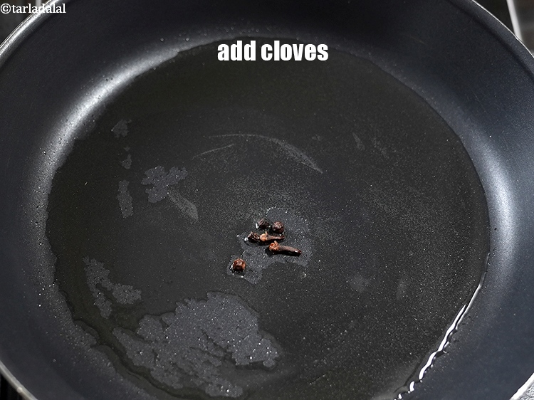 Step 9 – Add 2 <a href="https://www.tarladalal.com/glossary-cloves-laung-lavang-322i">cloves (laung / lavang)</a>.