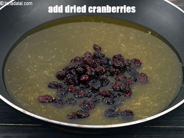 Step 6 – Add &frac14; cup <a href="https://www.tarladalal.com/glossary-dried-cranberries-1347i">dried cranberries</a>.