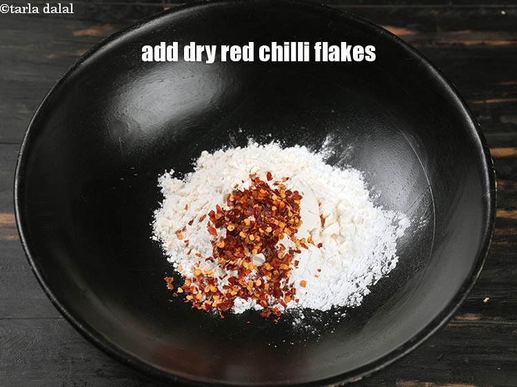 Step 5 – Add 1 tsp <a href="https://www.tarladalal.com/glossary-dry-red-chilli-flakes-paprika-338i">dry red chilli flakes (paprika)</a>.
