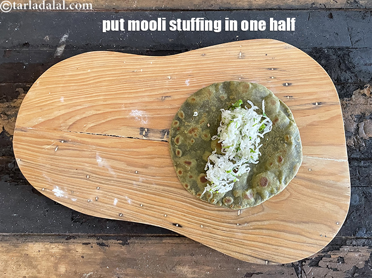 स्टेप 58 – परांठे के एक आधे हिस्से पर मूली की स्टफिंग रखें।