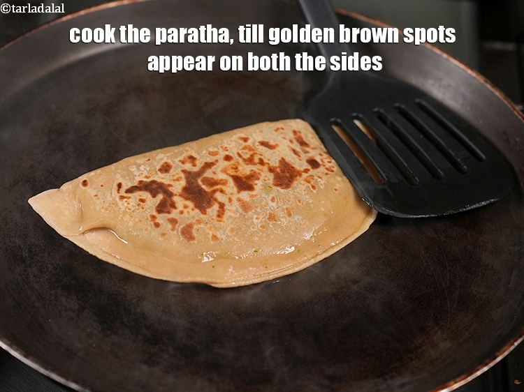 Step 31 – Cook the paratha, till golden brown spots appear on both the sides.