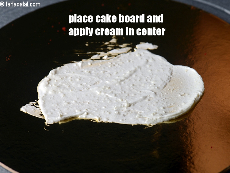 Step 36 – On a turn table place the cake board and apply little cream in the center.
