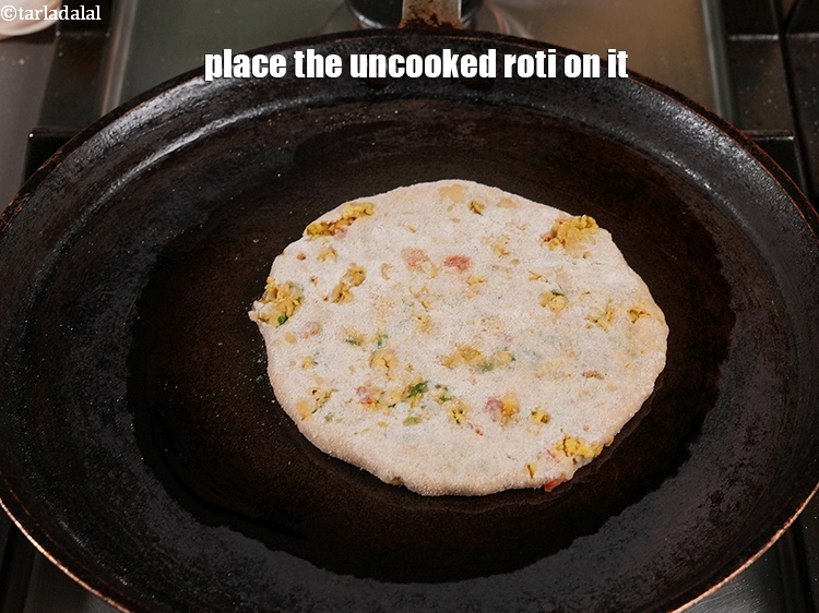 Step 40 – <meta charset="UTF-8" />Place the uncooked roti on it.&nbsp;