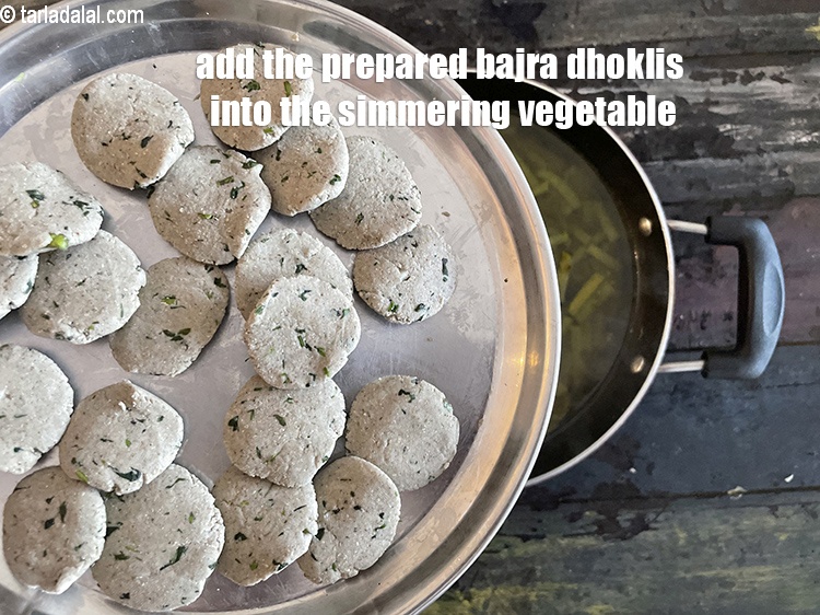 Step 31 – Add the bajra dhoklis into the simmering vegetable.