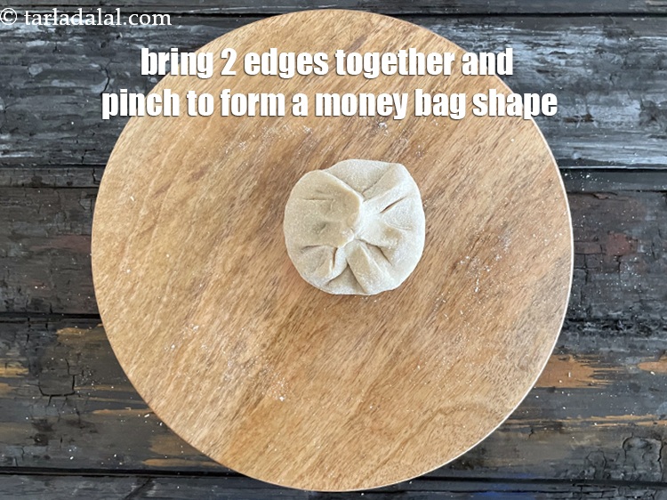 Step 33 – Bring the 2 edges together and pinch to form a money bag.