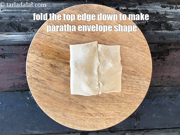Step 34 – Now fold the top edge of the roti to seal the paratha from the top. …