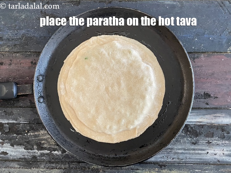 Step 34 – <meta charset="UTF-8" />Place the paratha gently on the tava.&nbsp;&nbsp;