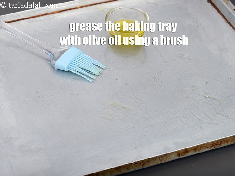 Step 32 – Grease the baking tray with <a href="https://www.tarladalal.com/glossary-olive-oil-451i">olive oil</a> using a brush.