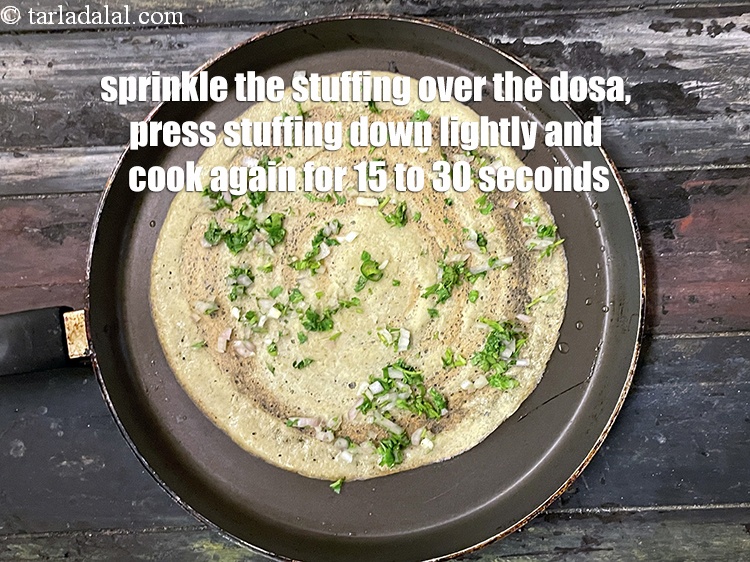 Step 33 – Sprinkle a portion of the stuffing evenly over the dosa.&nbsp;Press the stuffing&nbsp;lightly down and cook …