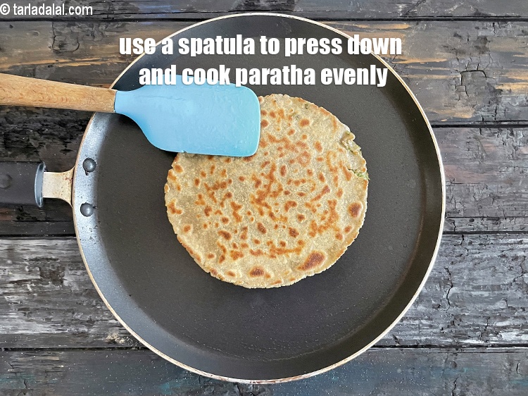 Step 39 – Use a spatula to press down to cook paratha evenly.