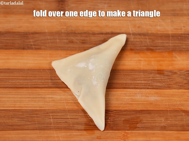 स्टेप 33 – एक किनारे को मोड़कर त्रिकोण बना लें।