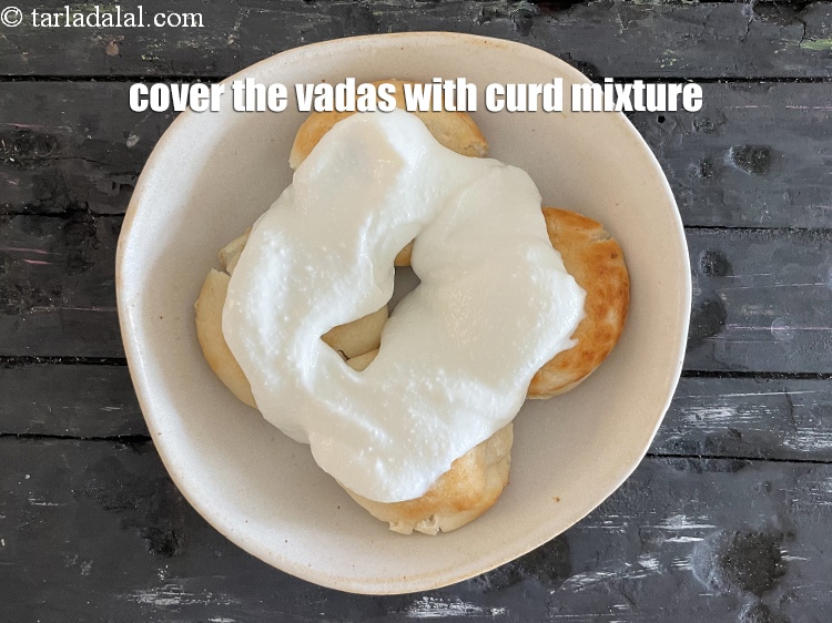 Step 33 – Cover the vadas&nbsp;with curd mixture.