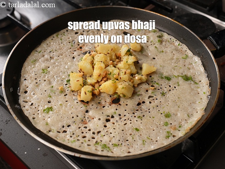 Step 34 – Spread the upvas bhaji evenly on the dosa.