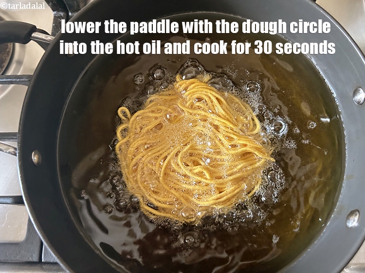 Step 34 – Lower the ladle with the dough circle into the hot oil and cook for 30 …