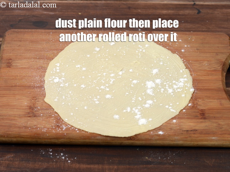 Step 36 – Dust some plain flour then place another rolled roti over it.