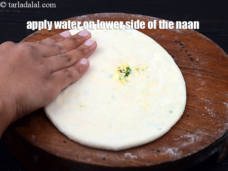 Step 36 – Apply little water on the lower side of the naan.