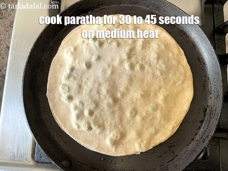 Step 35 – <meta charset="UTF-8" />Cook paratha for 30 to 45 seconds on a medium flame.&nbsp;&nbsp;
