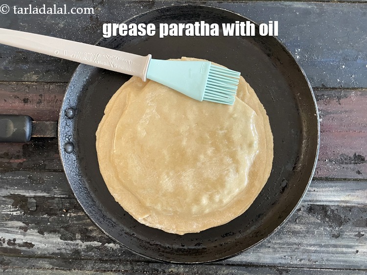 Step 36 – <meta charset="UTF-8" />Grease the top of the paratha with oil.&nbsp;