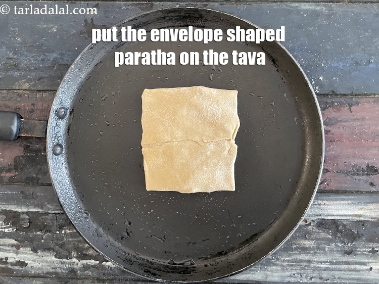 Step 36 – Put the envelope shaped paratha on the tava.