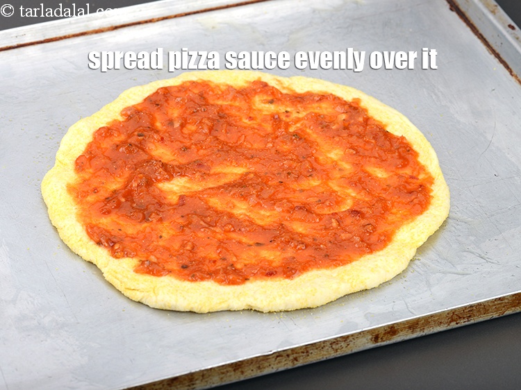 Step 34 – Spread &frac14; cup <a href="https://www.tarladalal.com/pizza-sauce-3250r">pizza sauce</a> evenly over it.&nbsp;
