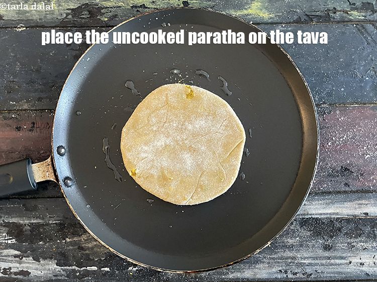 Step 50 – Place the uncooked paratha on the tava.