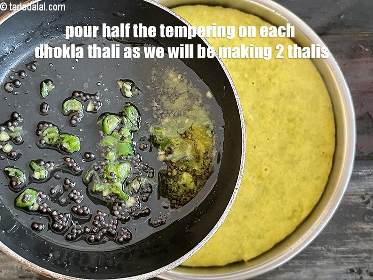 Step 34 – Pour half the tempering over the&nbsp;green peas dhoklas. The other half &nbsp;of the tempering will …