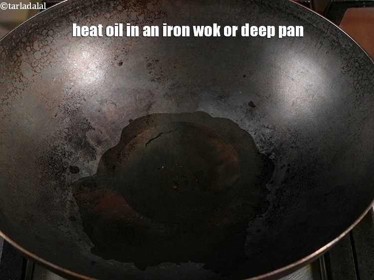 Step 34 – Heat 2 tbsp <a href="https://www.tarladalal.com/glossary-oil-671i">oil</a> in an iron wok or deep pan.