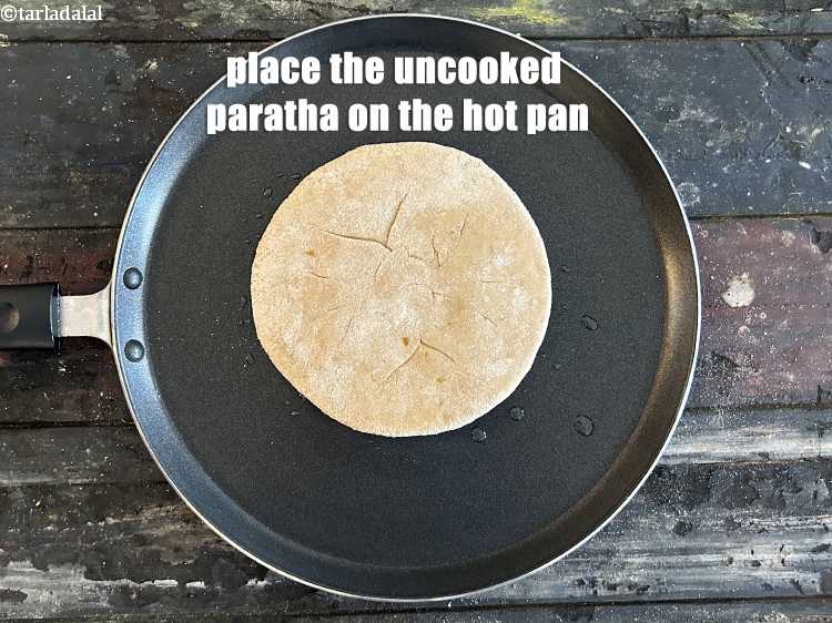 Step 41 – <meta charset="UTF-8" />Place the uncooked paratha on the tava.&nbsp;