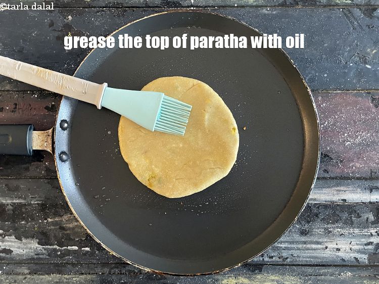 Step 52 – Grease the top of the paratha with oil using a brush.