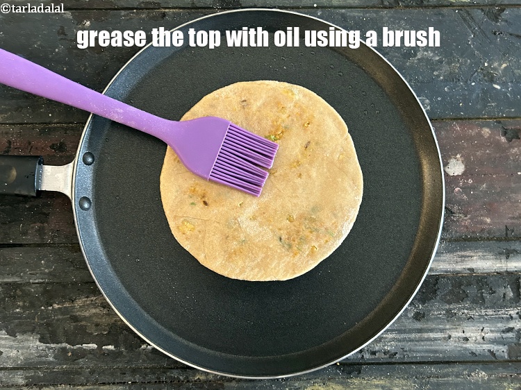 Step 46 – <meta charset="UTF-8" />Grease the top of the paratha with oil using a brush.&nbsp;<br /> &nbsp;