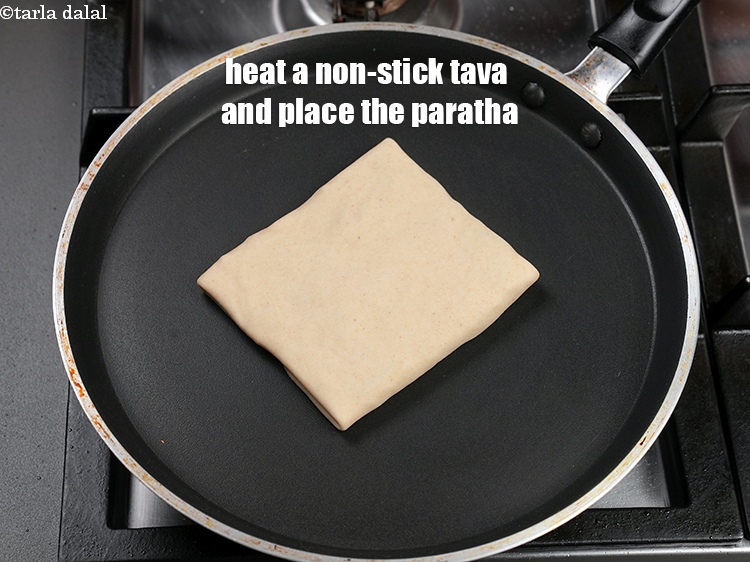 Step 37 – Heat a non-stick tava (griddle) and place the paratha.