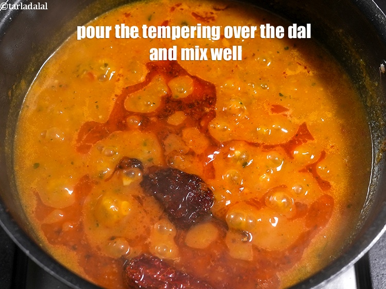 स्टेप 36 – तड़के को दाल के ऊपर डालें और अच्छी तरह मिलाएँ।
