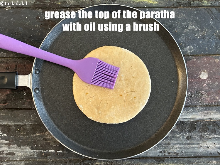 Step 43 – <meta charset="UTF-8" />Grease the top of the paratha with oil using a brush.&nbsp;<br /> &nbsp;