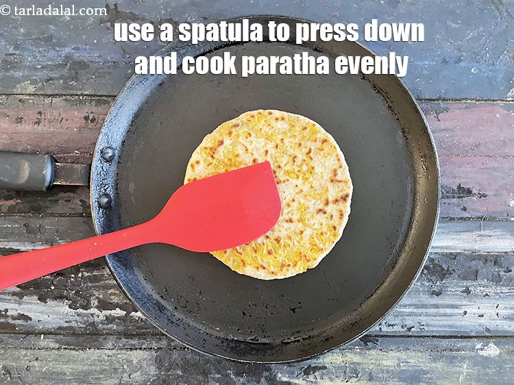Step 45 – <meta charset="UTF-8" />Use a spatula to press down on the paratha to cook it evenly.&nbsp;