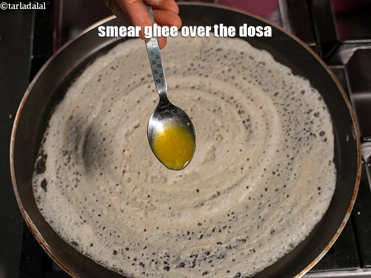 Step 38 – Smear &frac12; tsp of <a href="https://www.tarladalal.com/glossary-ghee-245i">ghee</a> over the dosa.