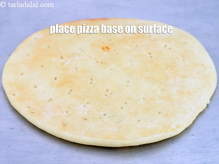 Step 40 – Place a <a href="https://www.tarladalal.com/glossary-thick-pizza-base-mota-pizza-base-2573i">pizza base</a> on a clean, dry surface.