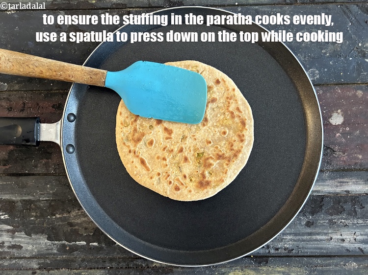 Step 48 – <meta charset="UTF-8" />To ensure that the stuffing in the paratha cooks evenly, use a spatula …